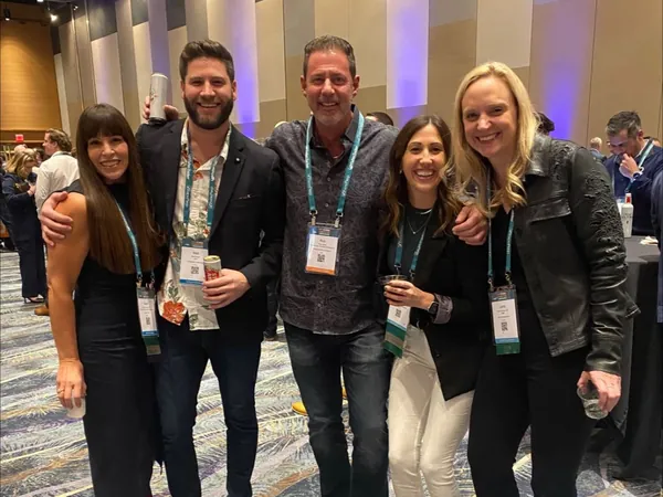Rob Lancit with four people wearing conference badges in a convention hall