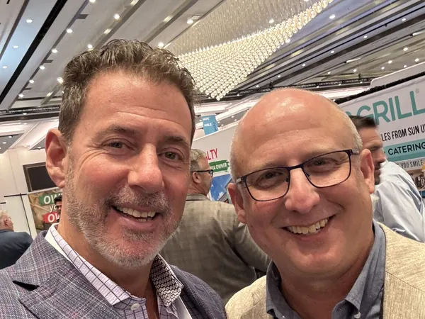 Rob Lancit and a man with glasses in a selfie in a convention hall