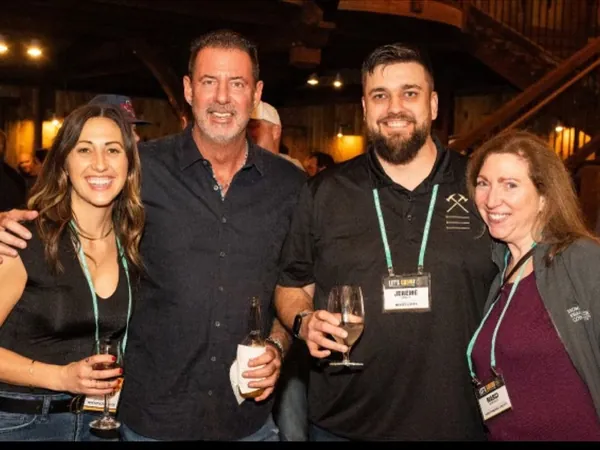 Rob Lancit with three people holding wine glasses at an evening reception