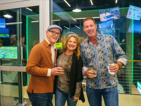 Rob Lancit with a man and a woman holding drinks at an evening event