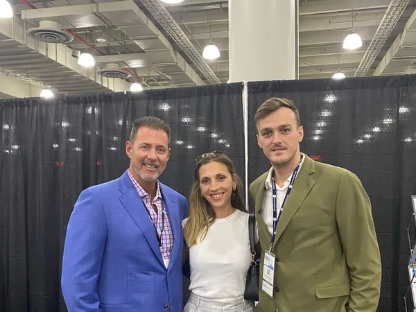Rob Lancit in a blue blazer with two people at a trade show booth
