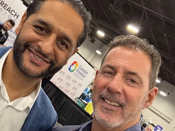 Rob Lancit and a man in a close selfie on an expo floor