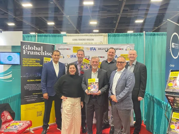 A group of seven at the Global Franchise booth on a trade show floor