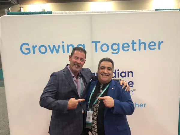 Rob Lancit and a man pointing at each other in front of a Growing Together banner