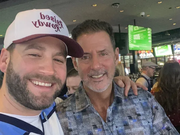 Rob Lancit and a man in a hockey jersey and cap in a selfie