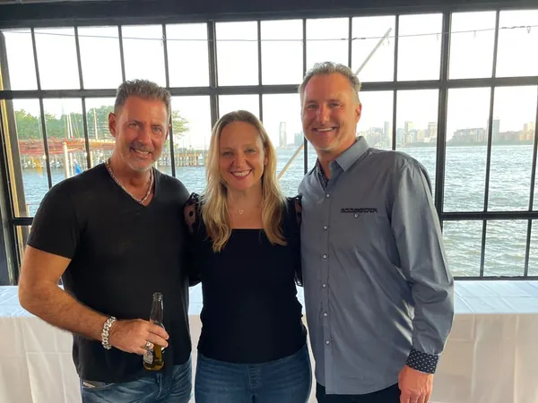 Rob Lancit, Liane and Mike Millett standing by a window over the water