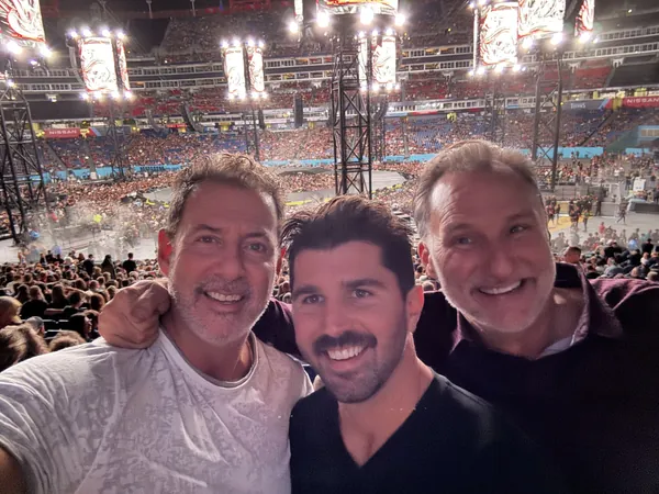 Rob Lancit, a younger man and Mike Millett in a stadium selfie at a Metallica concert