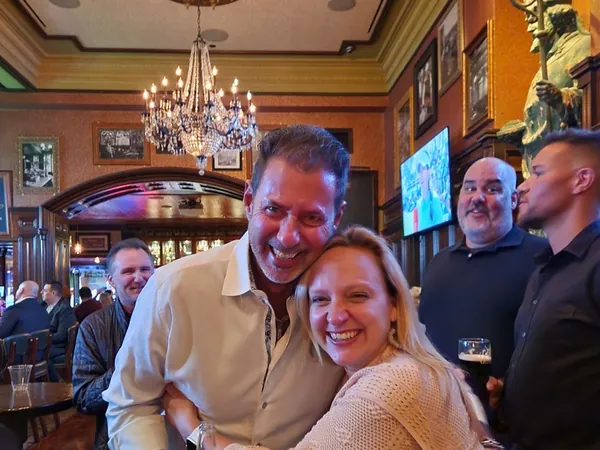 Rob Lancit hugging a woman in a busy pub