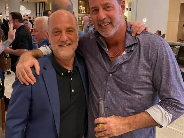 Rob Lancit with his arm around a man at a reception